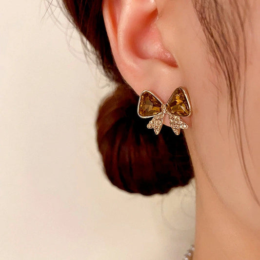 Model showcasing the dangle and style of the 14K Gold-plated Diamond Bow Earrings