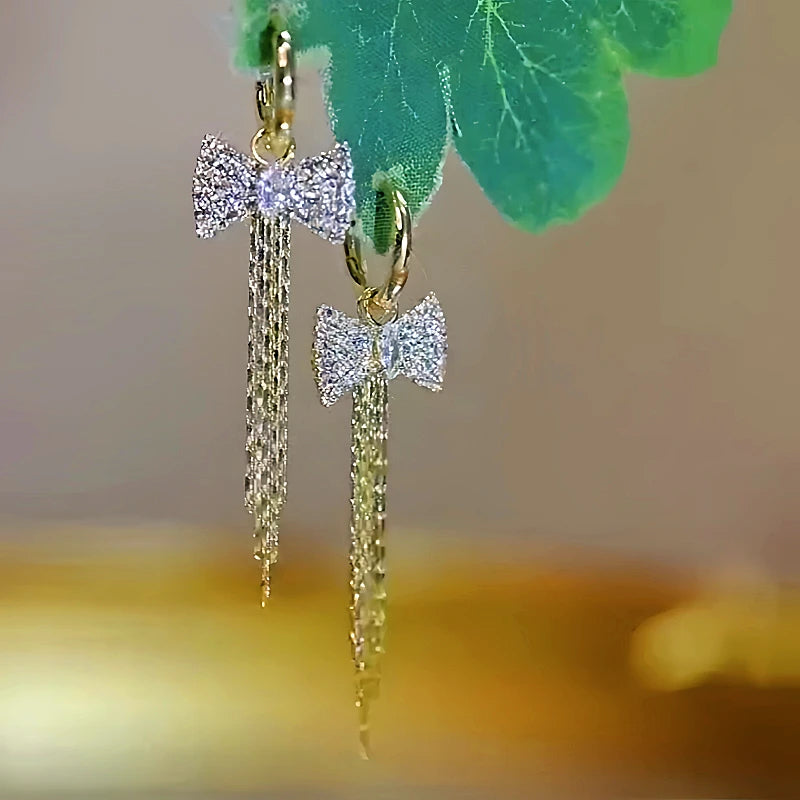 Angled view of the 14K Gold-plated Diamond Bow Tassel Earrings