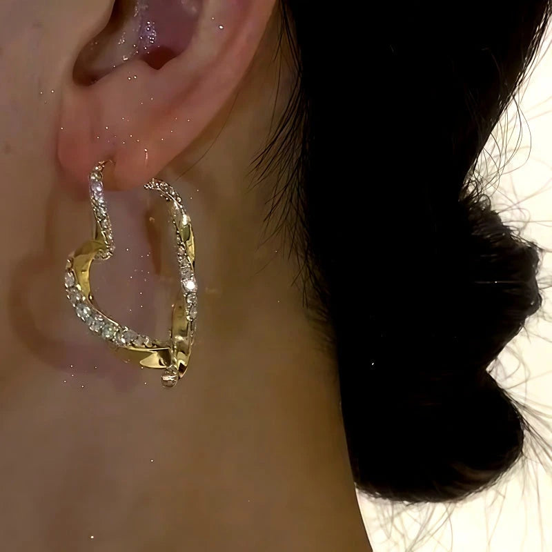 Model showcasing the dangle and style of the 14K Gold-plated Diamond Heart Earrings