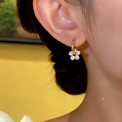 Model showcasing the dangle and style of the 14K Gold-plated Elegant Little Pendant Flower Earrings