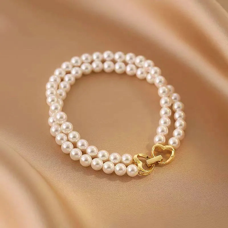 Model wearing the 14K Gold-plated Exquisite Heart-Design Double-Layer Pearl Bracelets to highlight its design on the wrist
