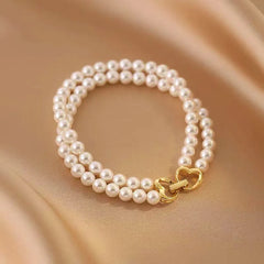 Model wearing the 14K Gold-plated Exquisite Heart-Design Double-Layer Pearl Bracelets to highlight its design on the wrist