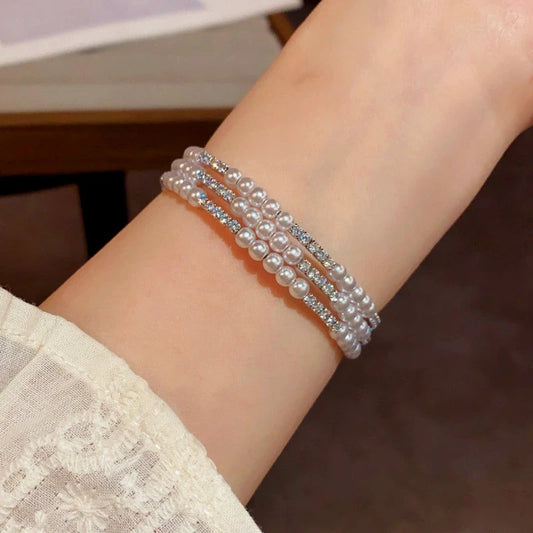 Model wearing the 14K Gold-plated Exquisite Pearl Elastic Stacking Bracelets to highlight its design on the wrist