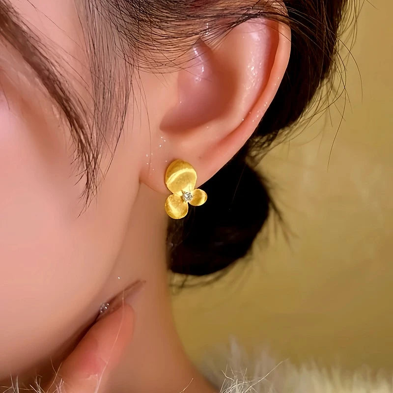 Model showcasing the dangle and style of the 14K Gold-plated Flower Stud Earrings