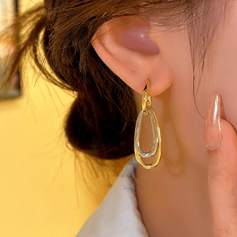 Model showcasing the dangle and style of the 14K Gold-plated Geometric Pendant Earrings