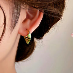 Close-up detail of the sparkling zircons and plating on the Emerald Heart Earrings