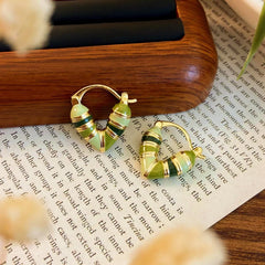 Model showcasing the dangle and style of the 14K Gold-plated Green Heart Earrings