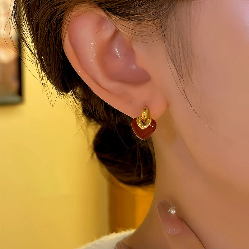 Model showcasing the dangle and style of the 14K Gold-plated Heart-Design Earrings