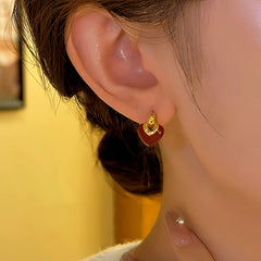 Model showcasing the dangle and style of the 14K Gold-plated Heart-Design Earrings