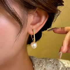 Model showcasing the dangle and style of the 14K Gold-plated Letter D Bead Earrings
