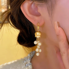 Model showcasing the dangle and style of the 14K Gold-plated Luxury Bead Tassel Earrings