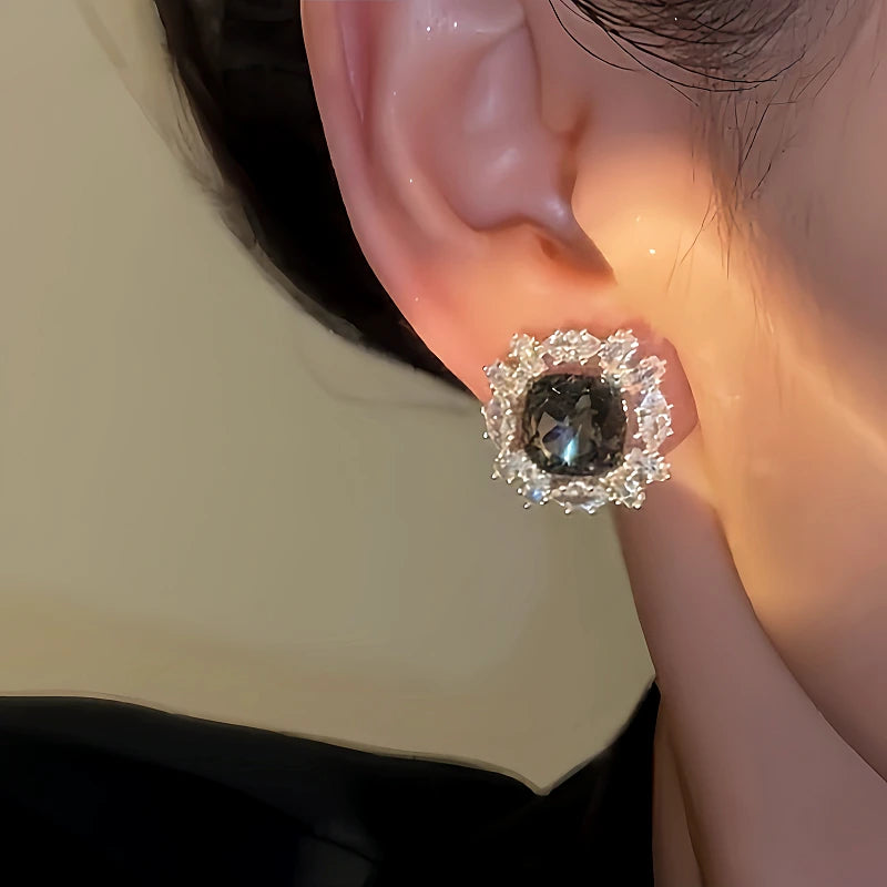 Model showcasing the dangle and style of the 14K Gold-plated Luxury Diamond-Studded Grey Crystal Earrings