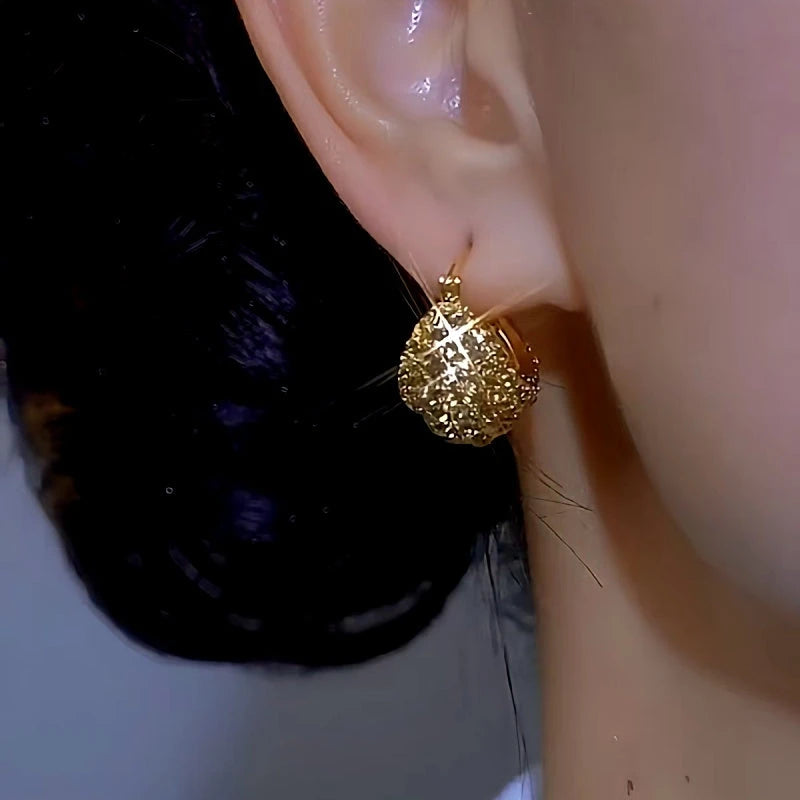 Model showcasing the dangle and style of the 14K Gold-plated Luxury Diamond Drop Earrings