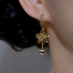 Model showcasing the dangle and style of the 14K Gold-plated Luxury Diamond Flower Earrings