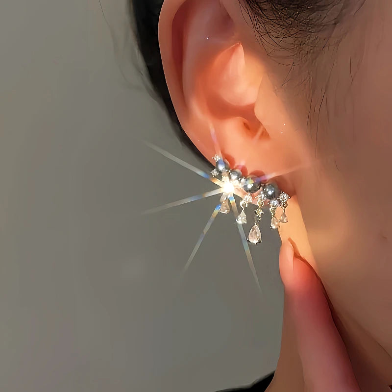 Angled view of the 14K Gold-plated Luxury Diamond Gray Pearl Tassel Earrings