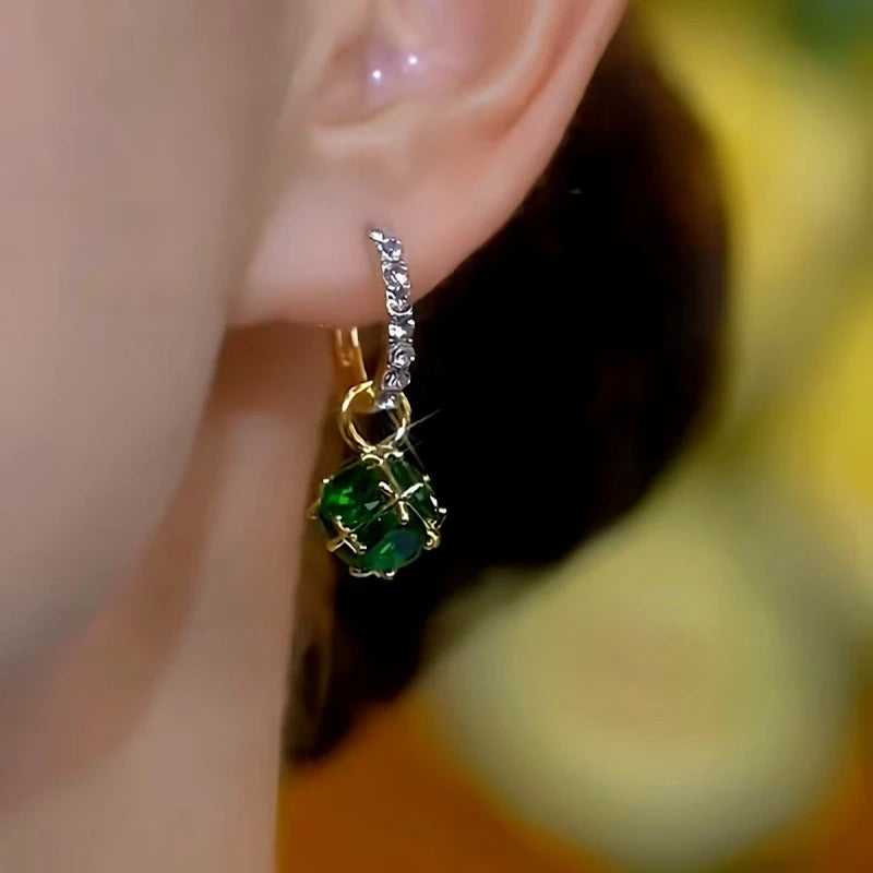 Model showcasing the dangle and style of the 14K Gold-plated Luxury Green Diamond Ball Earrings