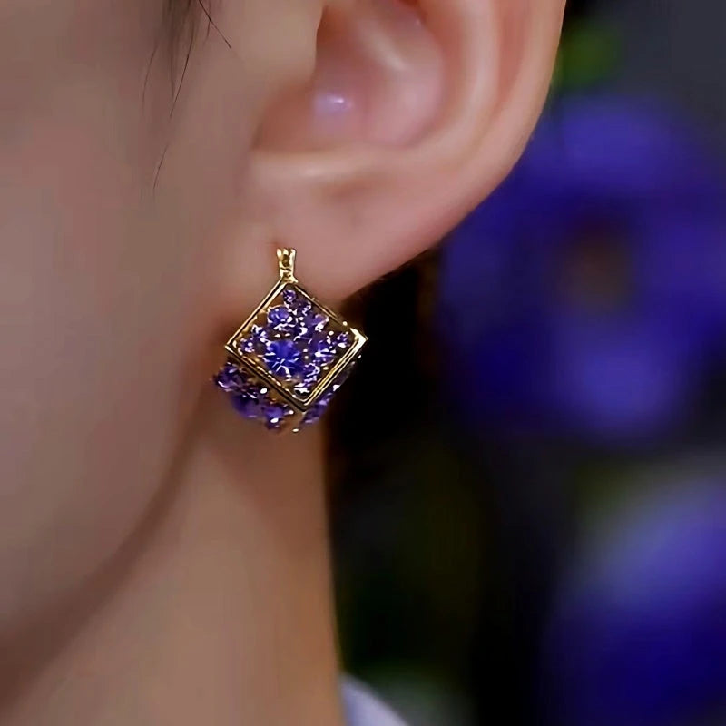 Model showcasing the dangle and style of the 14K Gold-plated Luxury Purple Zrcon Diamond Earrings