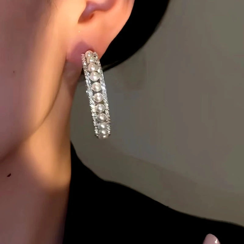 Model showcasing the dangle and style of the 14K Gold-plated Luxury Simple Beads Hoop Earrings