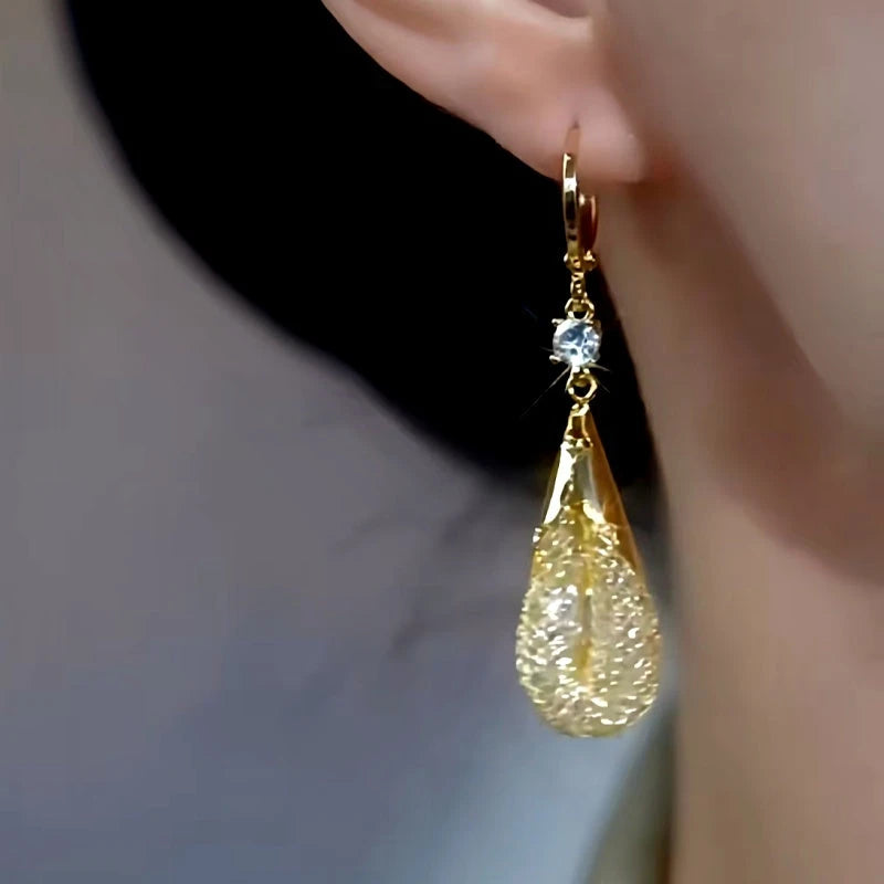 Model showcasing the dangle and style of the 14K Gold-plated Mesh Water Drop Earrings