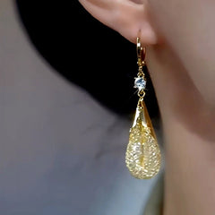 Model showcasing the dangle and style of the 14K Gold-plated Mesh Water Drop Earrings