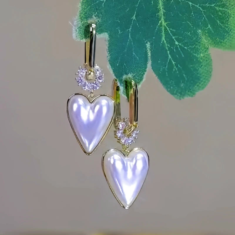 Model showcasing the dangle and style of the 14K Gold-plated Pearl Heart Earrings