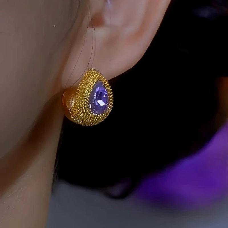 Textured gold teardrop purple gemstone stud earring on ear, front angle view