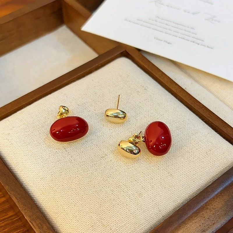 Angled view of the 14K Gold-plated Red Enamel Bean Earrings