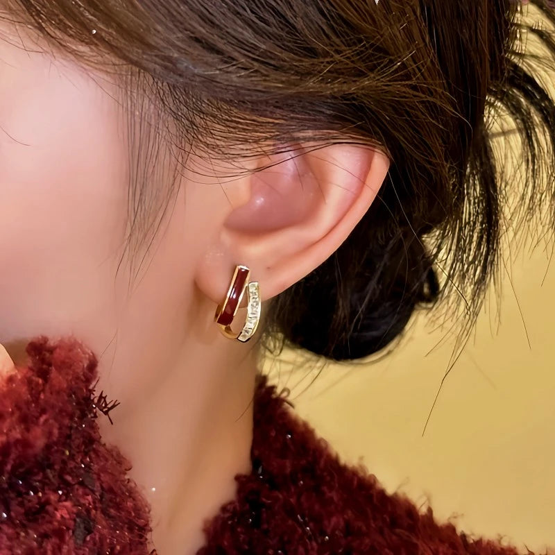 Model showcasing the dangle and style of the 14K Gold-plated Red Oil-Drop Earrings