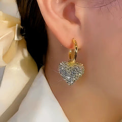 Model showcasing the dangle and style of the 14K Gold-plated Rhinestones Heart Earrings