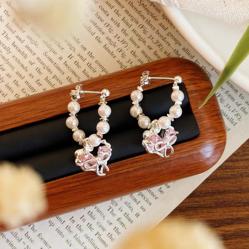 Angled view of the 14K Gold-plated Sweet Bow Heart Earrings