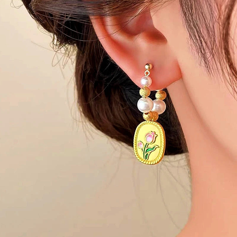 Model showcasing the dangle and style of the 14K Gold-plated Tulip Pearl Earrings