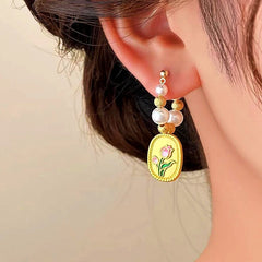 Model showcasing the dangle and style of the 14K Gold-plated Tulip Pearl Earrings