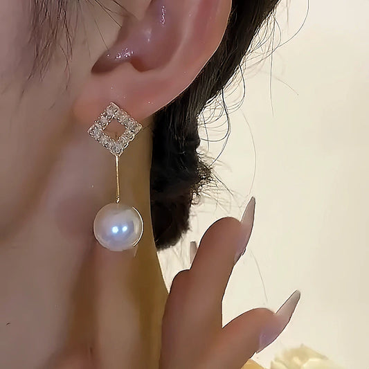 Model showcasing the dangle and style of the 14K Gold-plated Two-Piece Square Diamond Pearl Earrings