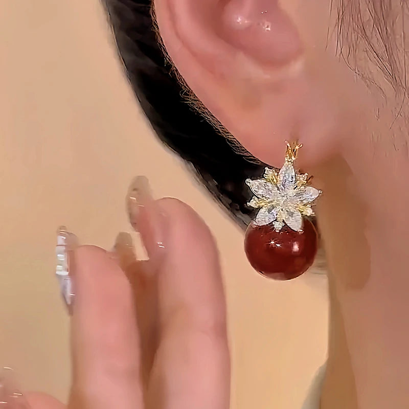 Model showcasing the dangle and style of the 14K Gold-plated Zircon Double-Sided Flower Red Pearl Earrings