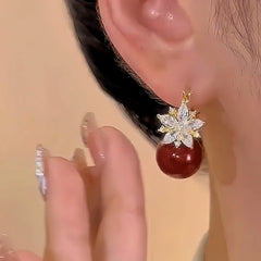 Model showcasing the dangle and style of the 14K Gold-plated Zircon Double-Sided Flower Red Pearl Earrings