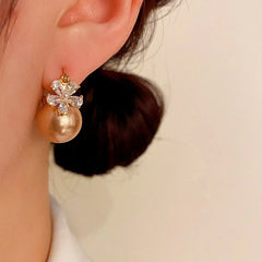 Model showcasing the dangle and style of the 14K Gold-plated Zircon Flower Pearl Earrings