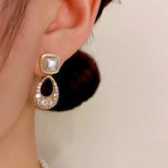 Model showcasing the dangle and style of the 14K Gold-plated Zircon Geometric Pearl Earrings