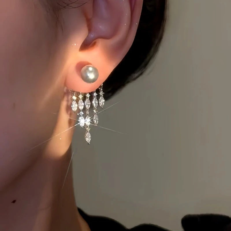 Model showcasing the dangle and style of the 14K Gold-plated Zircon Grey Bead Tassel Earrings