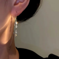 Model showcasing the dangle and style of the 14K Gold-plated Zircon Threader Tassel Earrings
