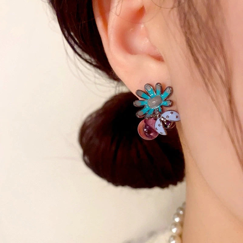 Model showcasing the dangle and style of the 14K Gold Plated Bee Petal Flower Purple Bead Earrings