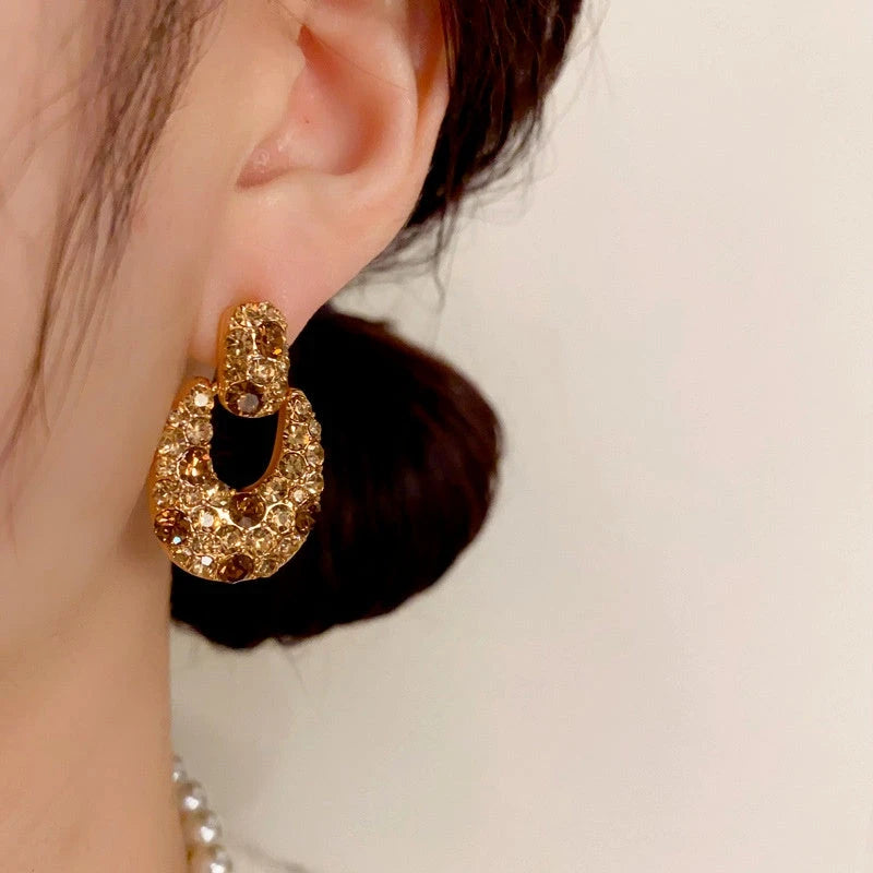 Close-up detail of the sparkling zircons and plating on the gold drop earrings