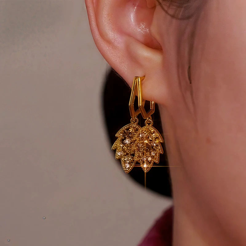 Model showcasing the dangle and style of the 14K Gold-Plated  Brown Diamond Leaf Earrings