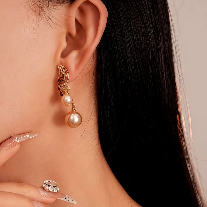 Model showcasing the dangle and style of the 14K Gold-Plated Brown Diamond Pearl Earrings