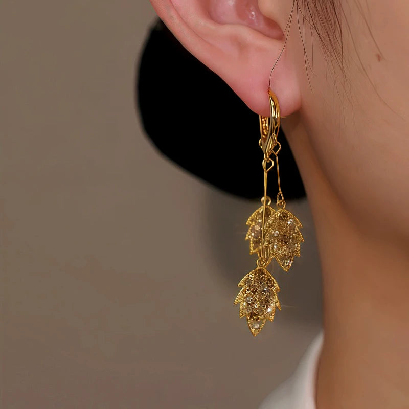 Model showcasing the dangle and style of the 14K Gold Plated Brown Zircon Wheat Tassel Earrings