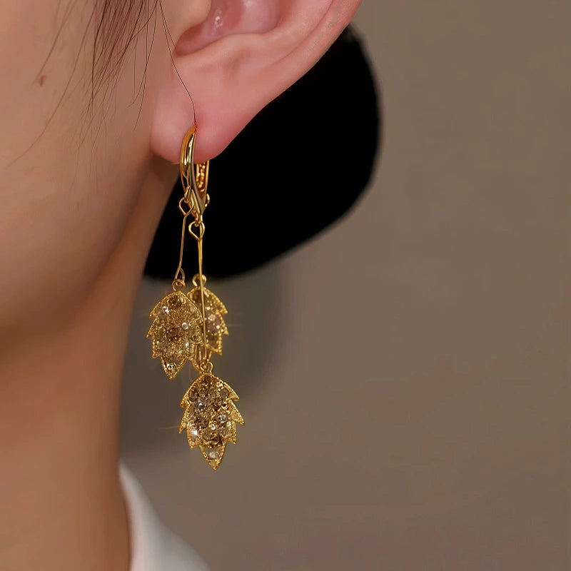 Close-up detail of the sparkling zircons and plating on the gold tassel earrings