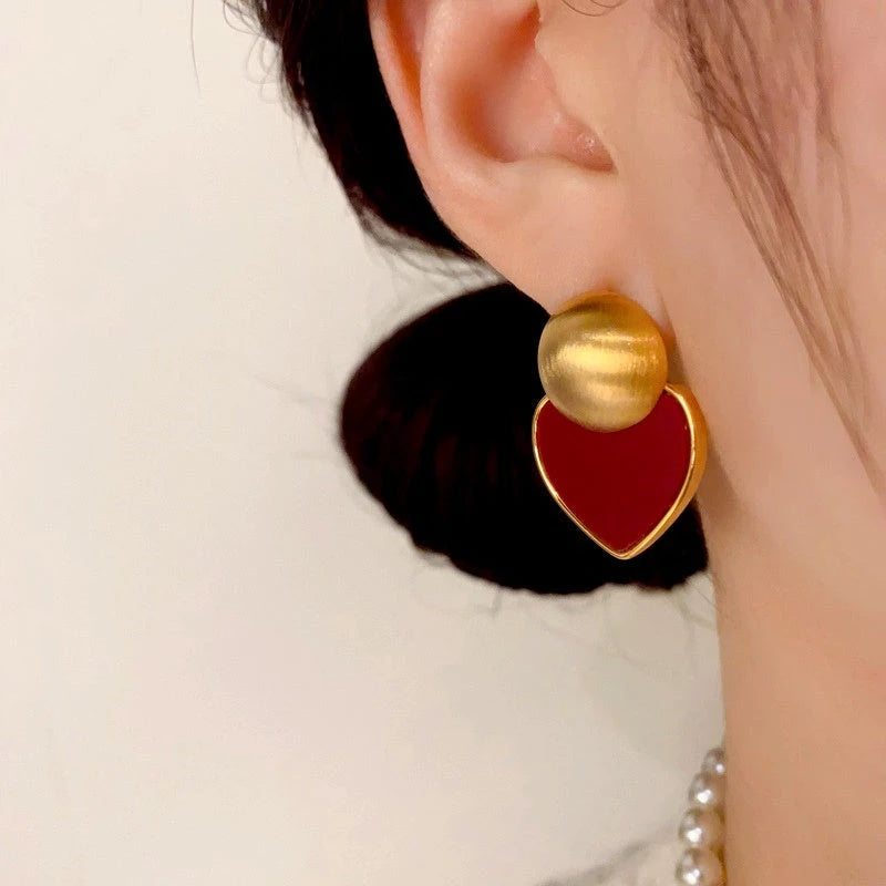 Close-up detail of the sparkling zircons and plating on the red heart earrings