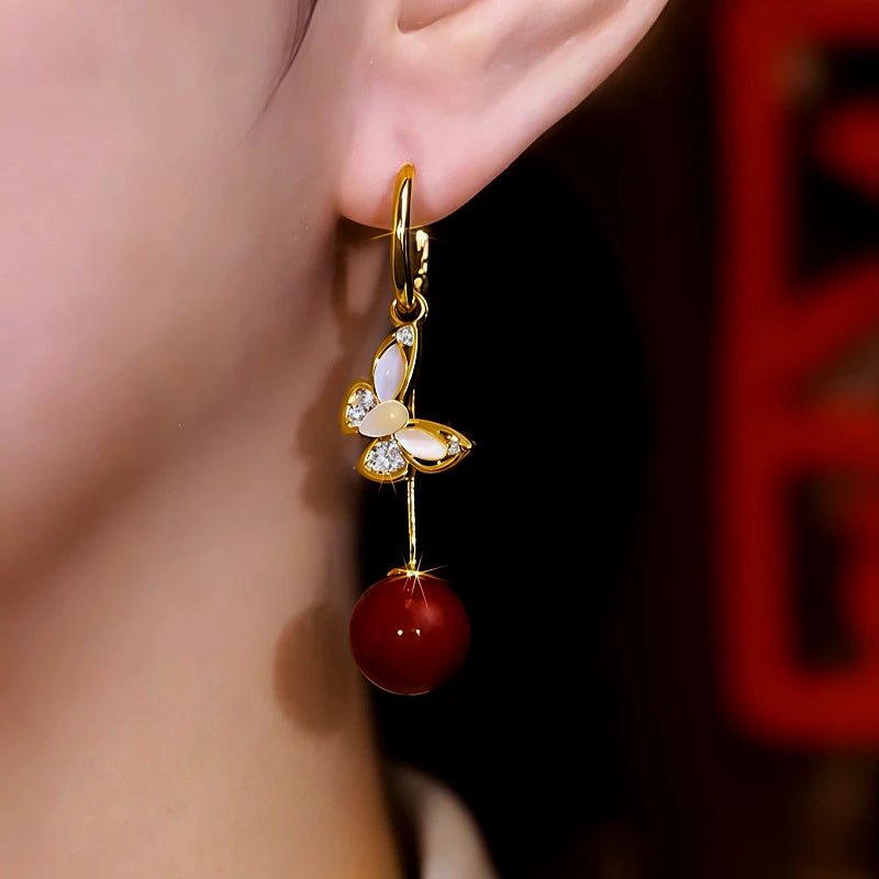 Model showcasing the dangle and style of the 14K Gold Plated Cat's Eye Stone Diamond Butterfly Pearl Earrings