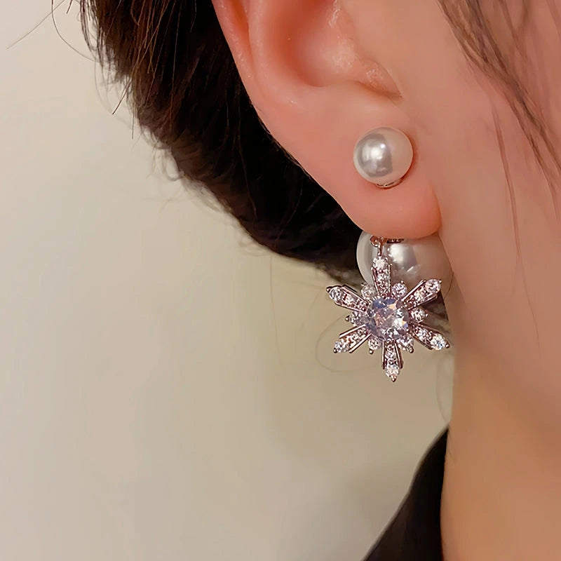 Model showcasing the dangle and style of the 14K Gold Plated Christmas Pearl Snowflake Earrings