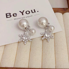 Angled view of the 14K Gold Plated Christmas Pearl Snowflake Earrings