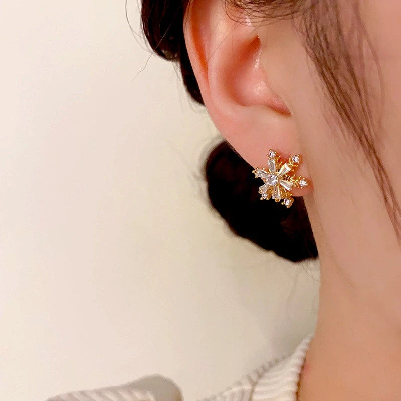 Model showcasing the dangle and style of the 14K Gold Plated Christmas Rotation Snowflake Stud Earrings